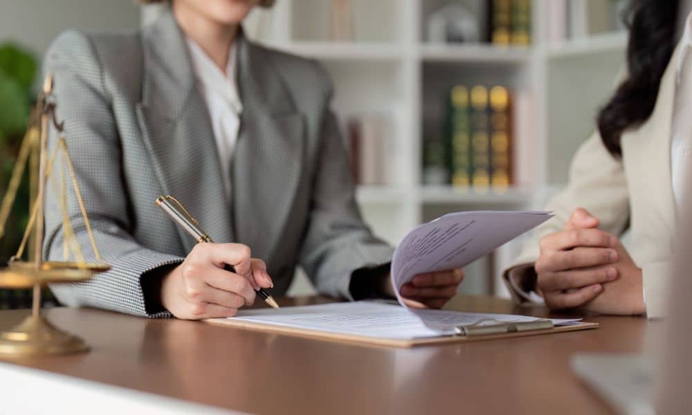 real estate attorney reviewing alta survey documents - ALTA SURVEY Denver A real estate attorney reviewing legal documents with a client, symbolizing the importance of ALTA surveys in Denver commercial property transactions.