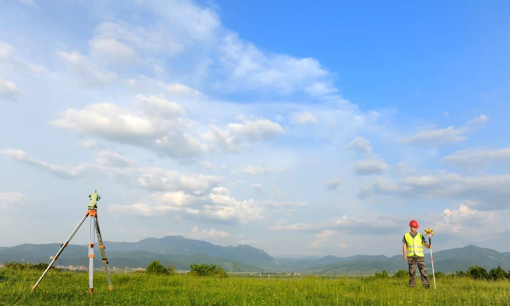 Land surveyor conducting a boundary survey with GPS equipment on open land in Denver
