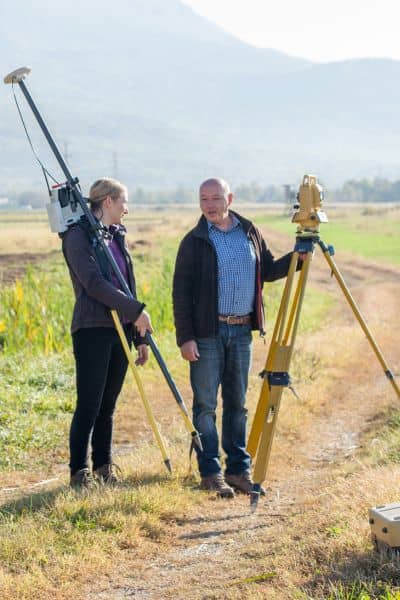 Licensed land surveyors conducting fieldwork with equipment, showing how ALTA Land Title Surveys are done during busy property development projects
