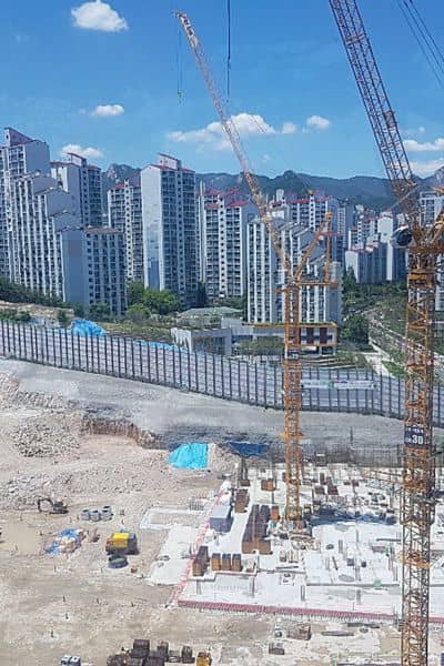 Construction site with cranes and urban redevelopment area showing where drone surveying helps detect settlement and land risks
