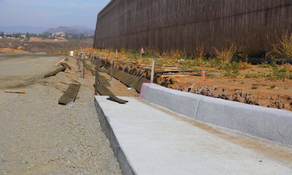 Construction crew forming new curbs and grading a drive-thru lane to support proper drainage design