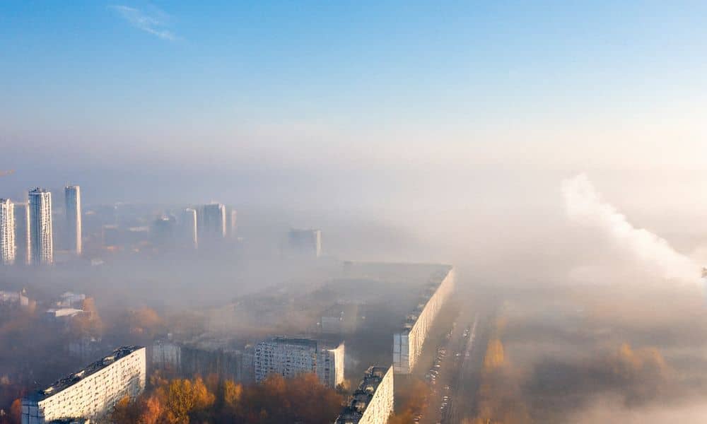 Thick urban smog covering city buildings during an air quality crisis, showing why demand for an environmental engineer is rising