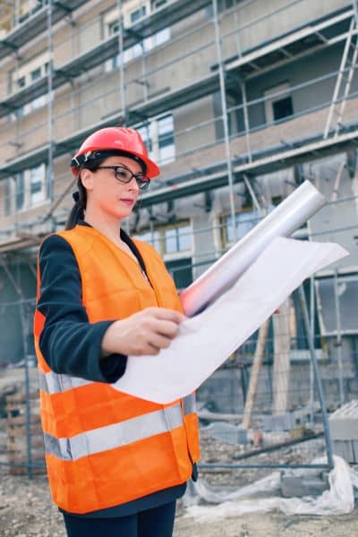 Site engineer reviewing construction plans while planning infrastructure for a large development project