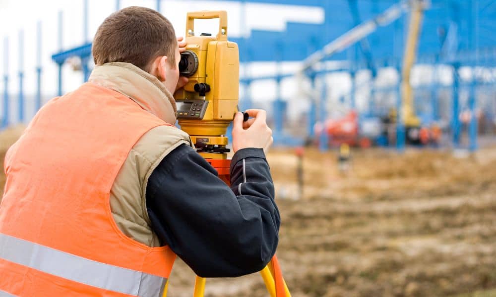Local surveyor checking site layout with a total station before construction begins